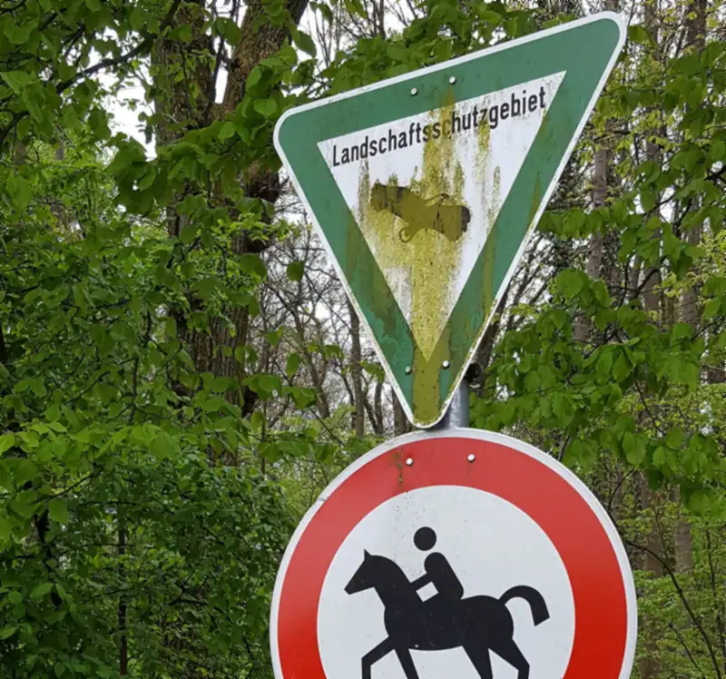 Rundes Verbotsschild für Reiter unter dem Schild Landschaftsschutzgebiet